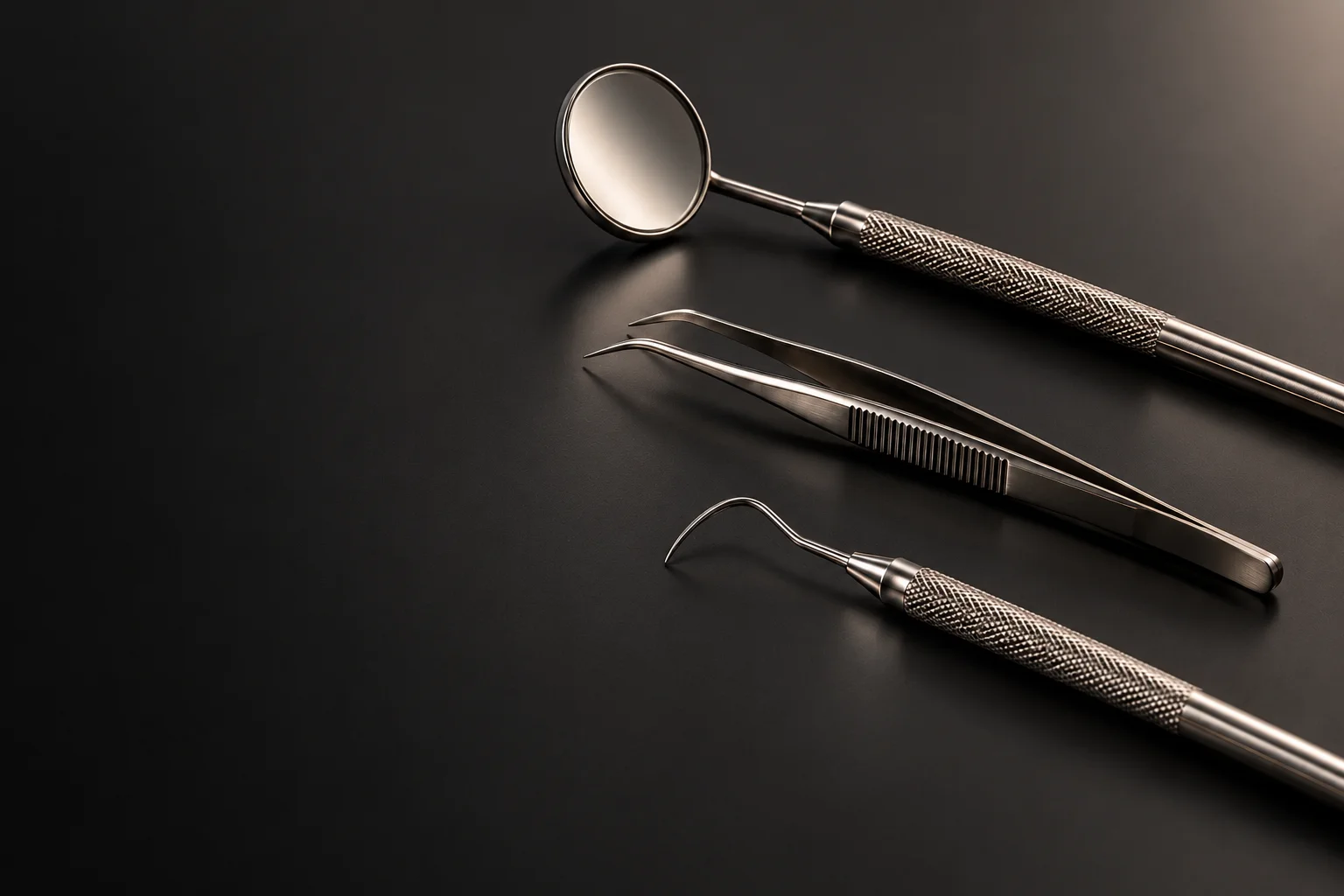 Conceptual still life of polished dental instruments, lit like fine jewelry on a matte graphite studio surface