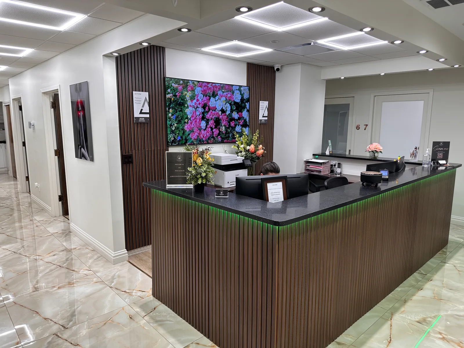The actual Dentist on Madison reception, with wood-front desk and clinic signage